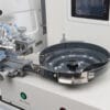 Automatic button feeder mechanism of the JACK JK-T1903GD computerized lockstitch button stitch machine with touch panel for precise and efficient button feeding.